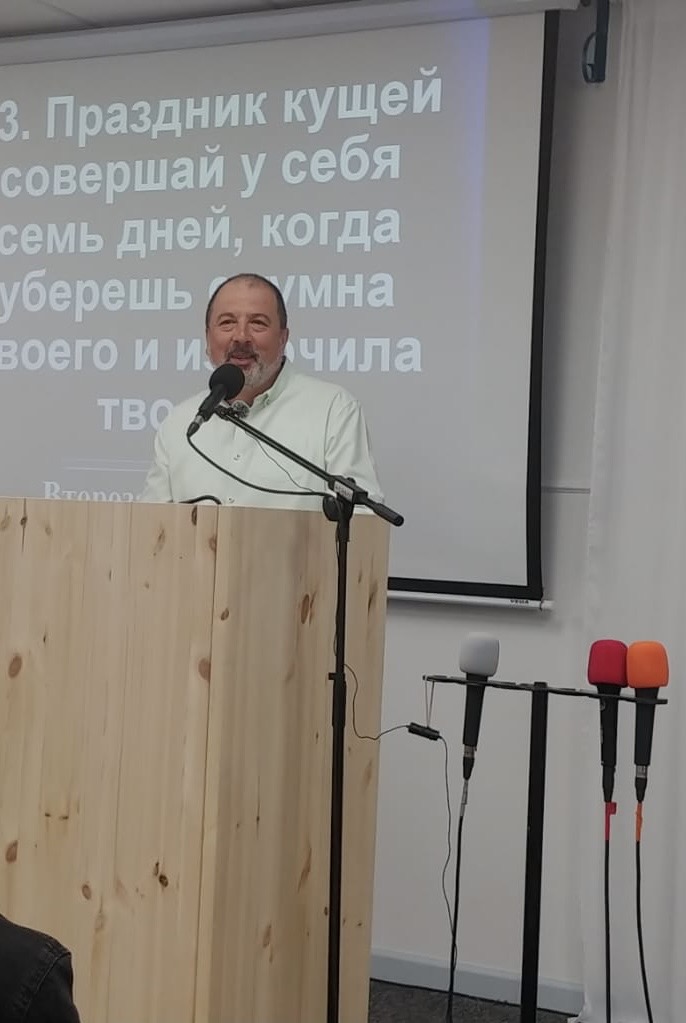 Дмитрий Балюк проповедует за кафедрой в церкви христиан веры евангельской